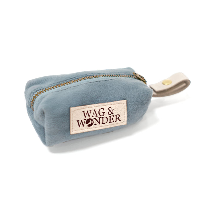 Dog poop bag holder in light blue velvet with vegan leather leash attachment.