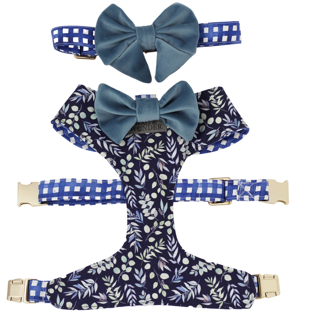 Dog harness in navy floral print and dog collar in navy plaid with blue velvet dog bows attached.